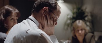 Movie still from “United 93” (2006), directed by Paul Greengrass – A person holding his head with one hand; Close Up shot, Over the shoulder angle