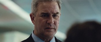 Movie still from “United 93” (2006), directed by Paul Greengrass – An older man in a suit and tie looking at the camera; Close Up shot, Low angle