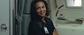 Movie still from “United 93” (2006), directed by Paul Greengrass – A woman sitting in a chair with her arms crossed; Close Up shot, Over the shoulder angle