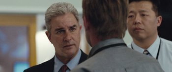 Movie still from “United 93” (2006), directed by Paul Greengrass – A man wearing a suit and tie talking to another man in front of a mirror; Close Up shot, Over the shoulder angle