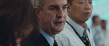 Movie still from “United 93” (2006), directed by Paul Greengrass – A man in a suit and tie looking at the camera; Close Up shot, Over the shoulder angle
