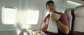Movie still from “United 93” (2006), directed by Paul Greengrass – A man sitting on top of an airplane eating food; Medium shot, High angle