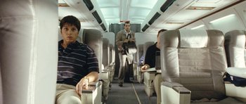 Movie still from “United 93” (2006), directed by Paul Greengrass – A man standing on top of an airplane with a laptop; Medium shot, High angle