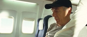 Movie still from “United 93” (2006), directed by Paul Greengrass – An older man sitting on a seat on an airplane; Close Up shot, Over the shoulder angle