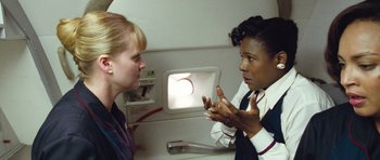 Movie still from “United 93” (2006), directed by Paul Greengrass – A woman talking to a flight attendant on a plane; Medium shot, High angle