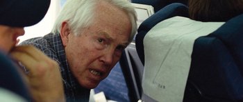 Movie still from “United 93” (2006), directed by Paul Greengrass – An older man looking at a bag on the back of a car; Close Up shot, High angle