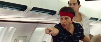 Movie still from “United 93” (2006), directed by Paul Greengrass – A young man points at something on a plane; Medium shot, Low angle