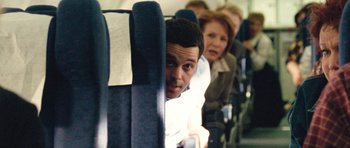 Movie still from “United 93” (2006), directed by Paul Greengrass – A group of people sitting on a seat on an airplane; Medium shot, High angle