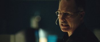 Movie still from “United 93” (2006), directed by Paul Greengrass – A man wearing glasses and a headset is looking at the camera; Close Up shot, Over the shoulder angle