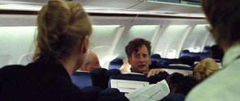 Movie still from “United 93” (2006), directed by Paul Greengrass – A group of people sitting on seats on an airplane; Medium shot, Over the shoulder angle