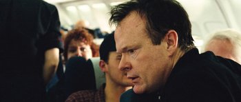 Movie still from “United 93” (2006), directed by Paul Greengrass – A man sitting next to another man on a plane; Close Up shot, Over the shoulder angle