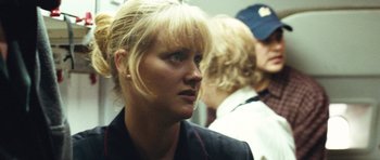 Movie still from “United 93” (2006), directed by Paul Greengrass – A woman with blonde hair and blue eye shadow; Close Up shot, Over the shoulder angle