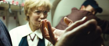 Movie still from “United 93” (2006), directed by Paul Greengrass – A woman in a white dress shirt and tie is holding an object in her hand; Extreme Close Up shot, Over the shoulder angle