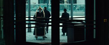Movie still from “Unknown” (2011), directed by Jaume Collet-Serra – A group of men standing around a building; Wide shot, Low angle