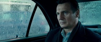 Movie still from “Unknown” (2011), directed by Jaume Collet-Serra – A man sitting in the back seat of a car looking out the window; Close Up shot, Over the shoulder angle