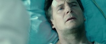 Movie still from “Unknown” (2011), directed by Jaume Collet-Serra – A person laying in a hospital bed with bandages on his head; Close Up shot, Overhead angle