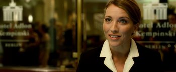 Movie still from “Unknown” (2011), directed by Jaume Collet-Serra – A person wearing a suit and smiling; Close Up shot, Over the shoulder angle