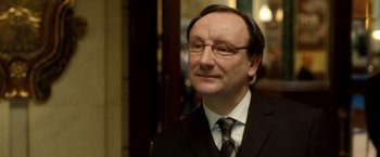 Movie still from “Unknown” (2011), directed by Jaume Collet-Serra – A person wearing a suit and tie; Close Up shot, Over the shoulder angle