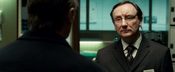Movie still from “Unknown” (2011), directed by Jaume Collet-Serra – A man in a suit and tie looking at another man in a suit and tie; Close Up shot, Over the shoulder angle
