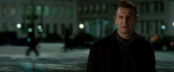 Movie still from “Unknown” (2011), directed by Jaume Collet-Serra – A man standing in front of a building at night; Close Up shot, Over the shoulder angle