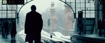 Movie still from “Unknown” (2011), directed by Jaume Collet-Serra – A man standing in front of a window with a view of a bridge; Wide shot, Low angle