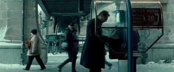 Movie still from “Unknown” (2011), directed by Jaume Collet-Serra – A man standing in front of an atm machine; Medium shot, Low angle