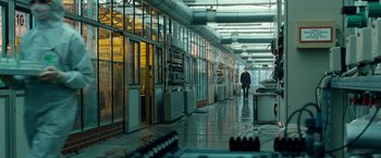 Movie still from “Unknown” (2011), directed by Jaume Collet-Serra – A man walking down a hallway in a building; Wide shot, Over the shoulder angle