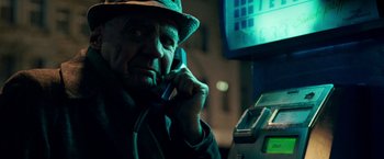 Movie still from “Unknown” (2011), directed by Jaume Collet-Serra – An older man talking on a phone next to a pay phone; Close Up shot, Low angle