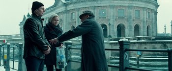 Movie still from “Unknown” (2011), directed by Jaume Collet-Serra – A man and a woman standing next to each other on a bridge; Medium shot, Over the shoulder angle