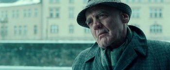 Movie still from “Unknown” (2011), directed by Jaume Collet-Serra – An older man wearing a hat and a suit; Close Up shot, Low angle
