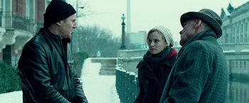 Movie still from “Unknown” (2011), directed by Jaume Collet-Serra – A man and a woman standing next to each other on a sidewalk; Medium shot, Over the shoulder angle
