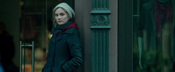 Movie still from “Unknown” (2011), directed by Jaume Collet-Serra – A woman standing in front of a green pillar; Medium shot, Over the shoulder angle