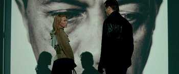 Movie still from “Unknown” (2011), directed by Jaume Collet-Serra – A man and a woman standing next to each other in front of a picture; Medium shot, Over the shoulder angle