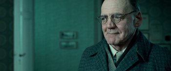 Movie still from “Unknown” (2011), directed by Jaume Collet-Serra – An older man wearing glasses and a suit; Close Up shot, Over the shoulder angle