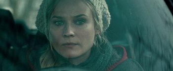 Movie still from “Unknown” (2011), directed by Jaume Collet-Serra – A person wearing a hat and a scarf; Close Up shot, Over the shoulder angle