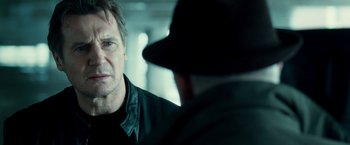 Movie still from “Unknown” (2011), directed by Jaume Collet-Serra – A man wearing a black jacket and a black hat; Close Up shot, Over the shoulder angle