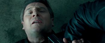 Movie still from “Unknown” (2011), directed by Jaume Collet-Serra – A man is holding a cell phone while lying down; Close Up shot, Low angle