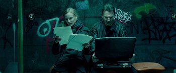 Movie still from “Unknown” (2011), directed by Jaume Collet-Serra – A man and a woman sitting next to each other on a bench; Medium shot, Low angle