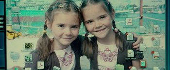 Movie still from “Unknown” (2011), directed by Jaume Collet-Serra – Two little girls posing for a picture together; Close Up shot, Overhead angle