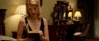 Movie still from “Unknown” (2011), directed by Jaume Collet-Serra – A beautiful young lady reading a book in front of a mirror; Medium shot, Low angle