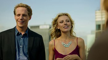 Movie still from “Urge” (2016), directed by Aaron Kaufman – A man and a woman standing next to each other; Medium shot, Low angle