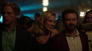 Movie still from “Urge” (2016), directed by Aaron Kaufman – A woman standing next to a man in a suit; Medium shot, Over the shoulder angle