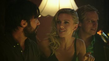 Movie still from “Urge” (2016), directed by Aaron Kaufman – A man and a woman talking to each other in front of a lamp; Close Up shot, Over the shoulder angle