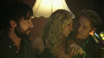 Movie still from “Urge” (2016), directed by Aaron Kaufman – A group of people sitting in a room together; Close Up shot, Over the shoulder angle