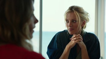 Movie still from “Urge” (2016), directed by Aaron Kaufman – A woman looking at another woman in front of a window; Close Up shot, Over the shoulder angle