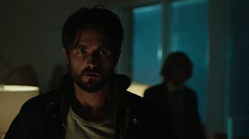 Movie still from “Urge” (2016), directed by Aaron Kaufman – A person wearing a jacket; Close Up shot, Over the shoulder angle