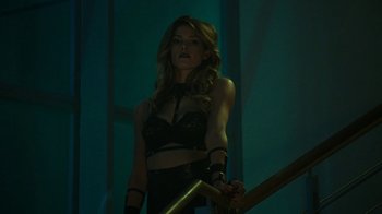 Movie still from “Urge” (2016), directed by Aaron Kaufman – A beautiful woman holding a sword while standing on stairs; Medium shot, Low angle