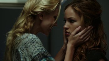 Movie still from “Urge” (2016), directed by Aaron Kaufman – Two young women talking to each other in a room; Close Up shot, Over the shoulder angle