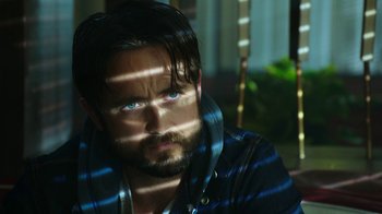 Movie still from “Urge” (2016), directed by Aaron Kaufman – A man with a beard and blue eyes; Close Up shot, Low angle