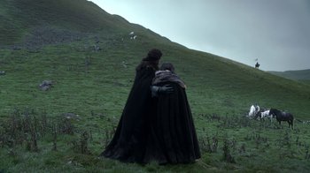 Movie still from “Game of Thrones” (2011), created by D.B. Weiss – Two people in black capes standing on a hill; Medium shot, Low angle